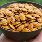 A bowl of crispy roasted Kabocha seeds, perfectly seasoned and ready to enjoy as a healthy snack.